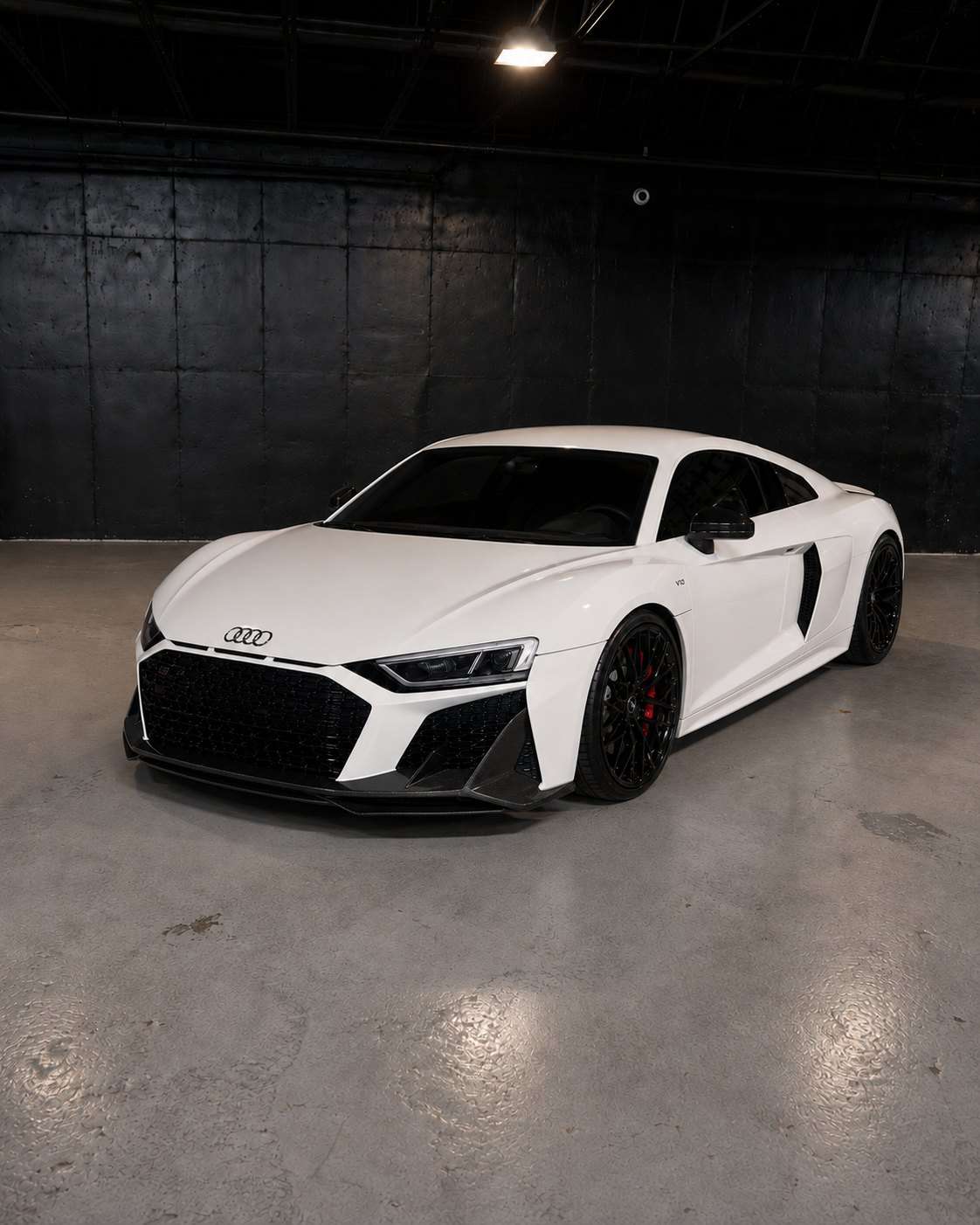 White Audi R8 V10 with red interior, front three quarter in a dark studio