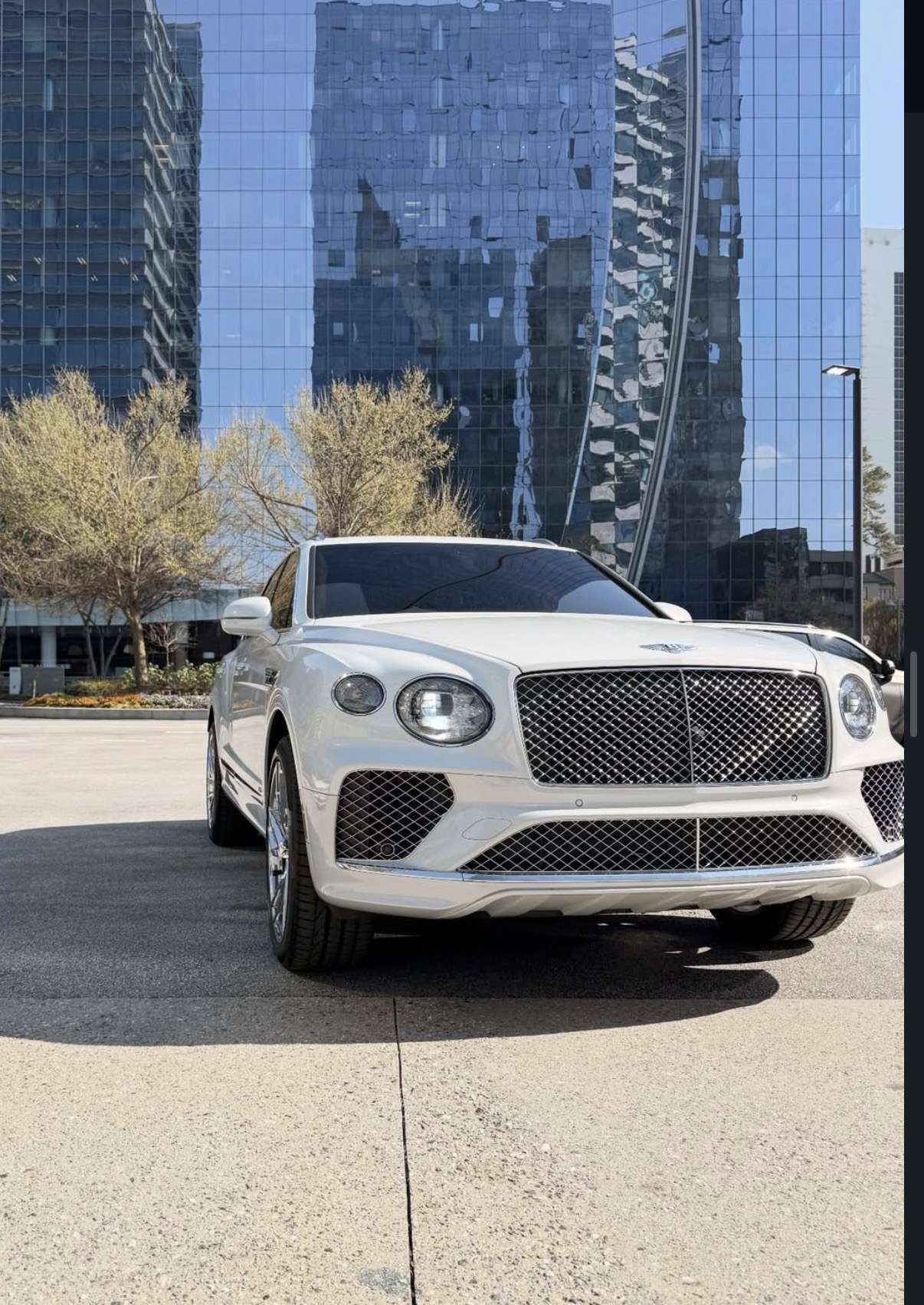 White Bentley Bentayga in front of Atlanta glass towers