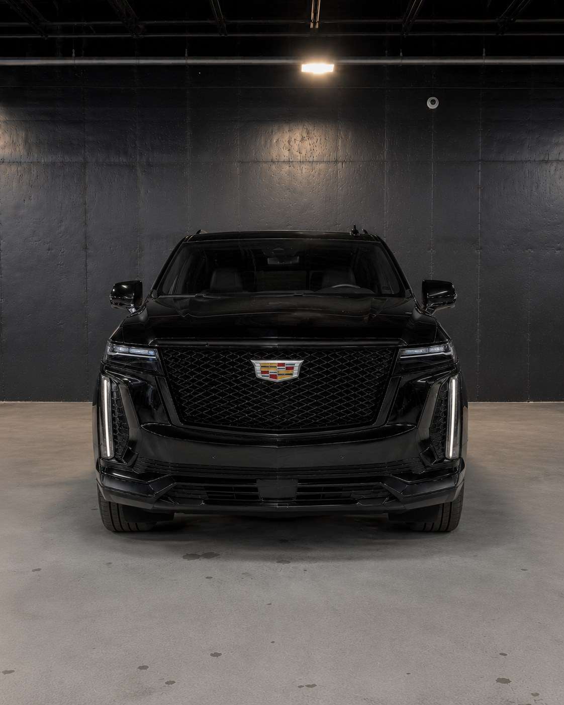 Black Cadillac Escalade ESV, straight front view with the blacked-out mesh grille