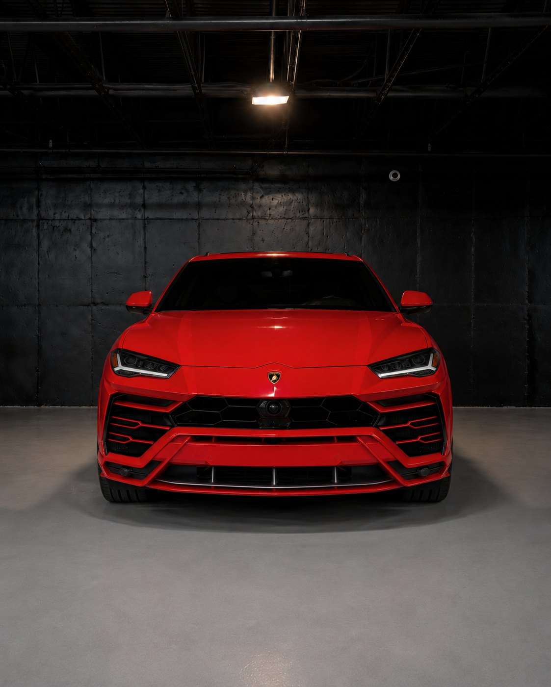 Red Lamborghini Urus, straight front view in the studio
