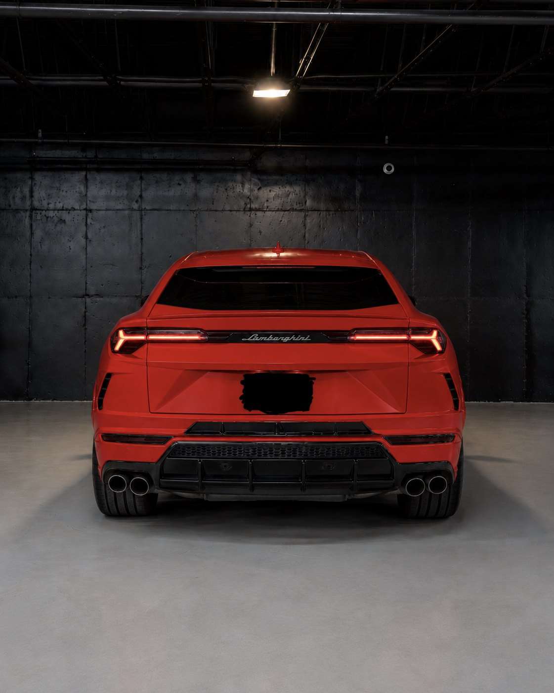 Red Lamborghini Urus, straight rear view in the studio