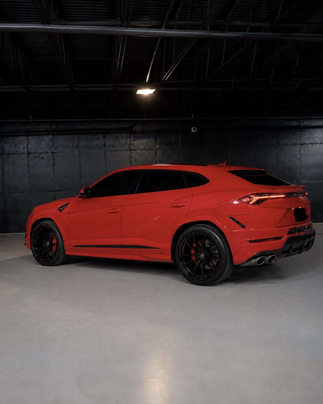 Red Lamborghini Urus, rear three quarter in the studio