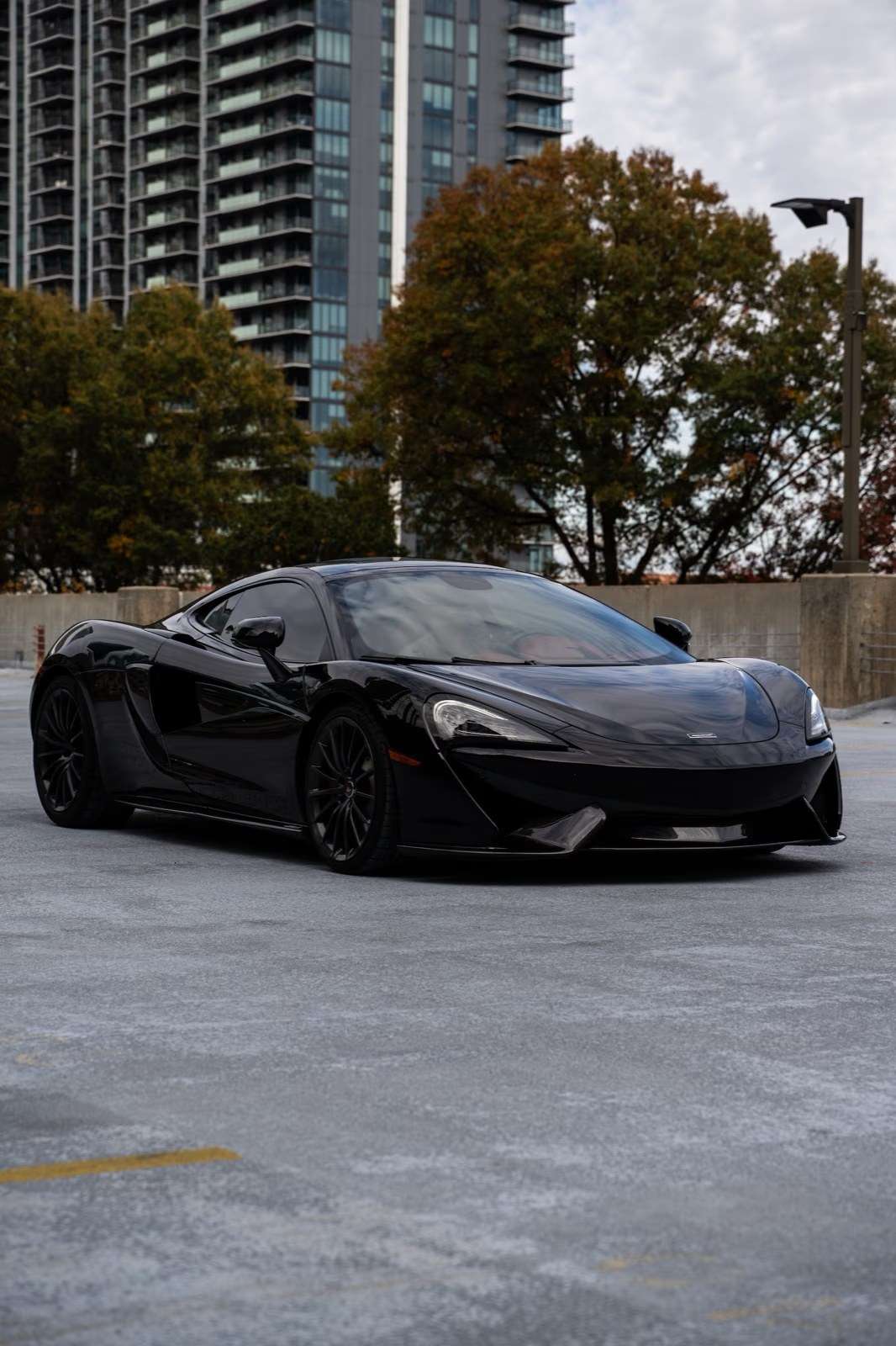 Black McLaren 570GT on an Atlanta parking deck, front three quarter