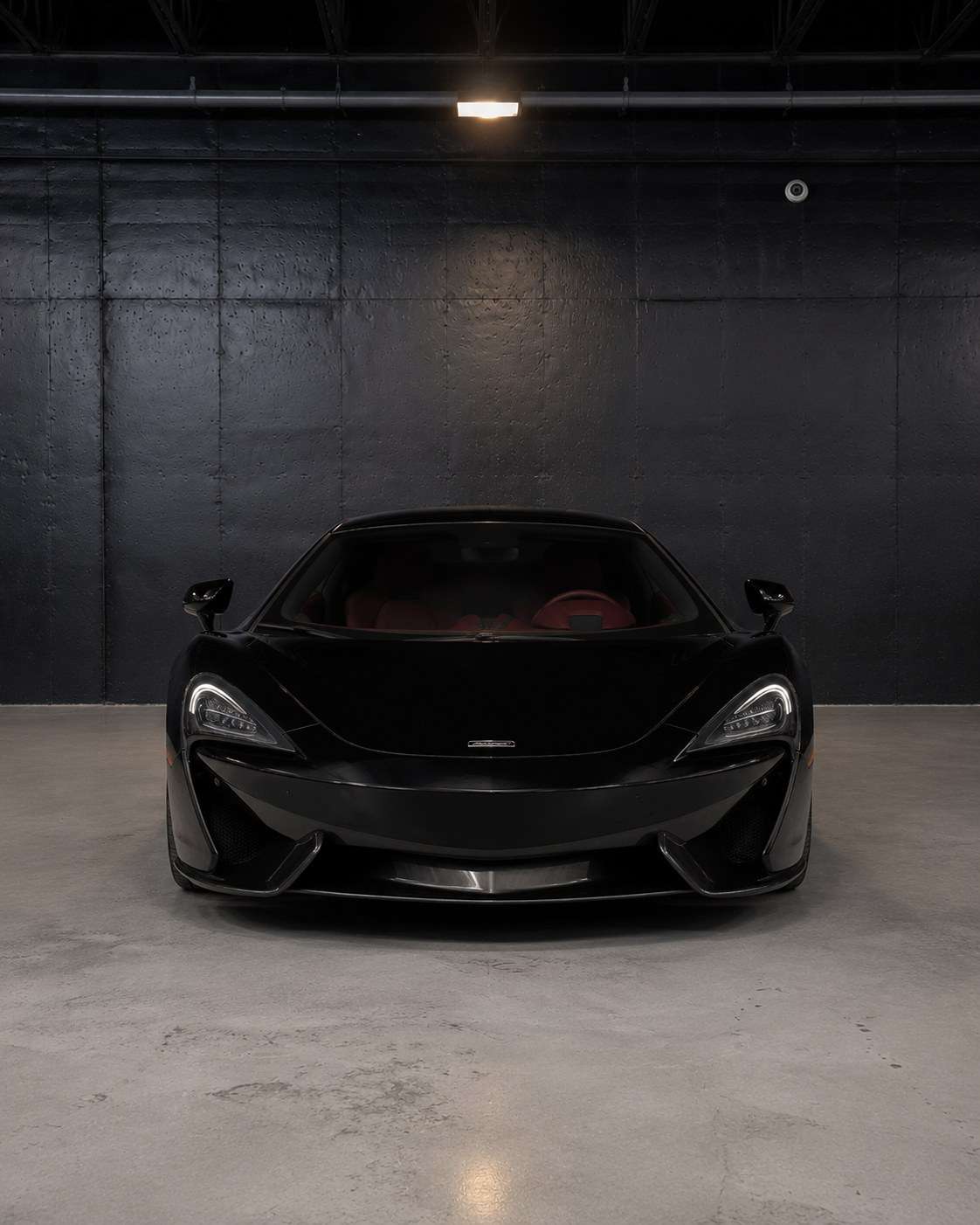 Black McLaren 570GT, straight front view in the studio