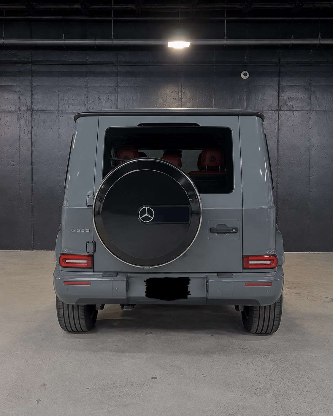 Grey Mercedes G63 with spare wheel cover, straight rear in the studio