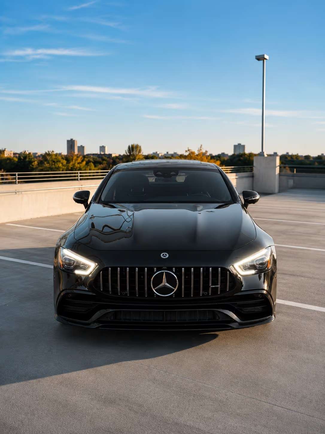 Black Mercedes-AMG GT 43 straight on at golden hour on an Atlanta parking deck