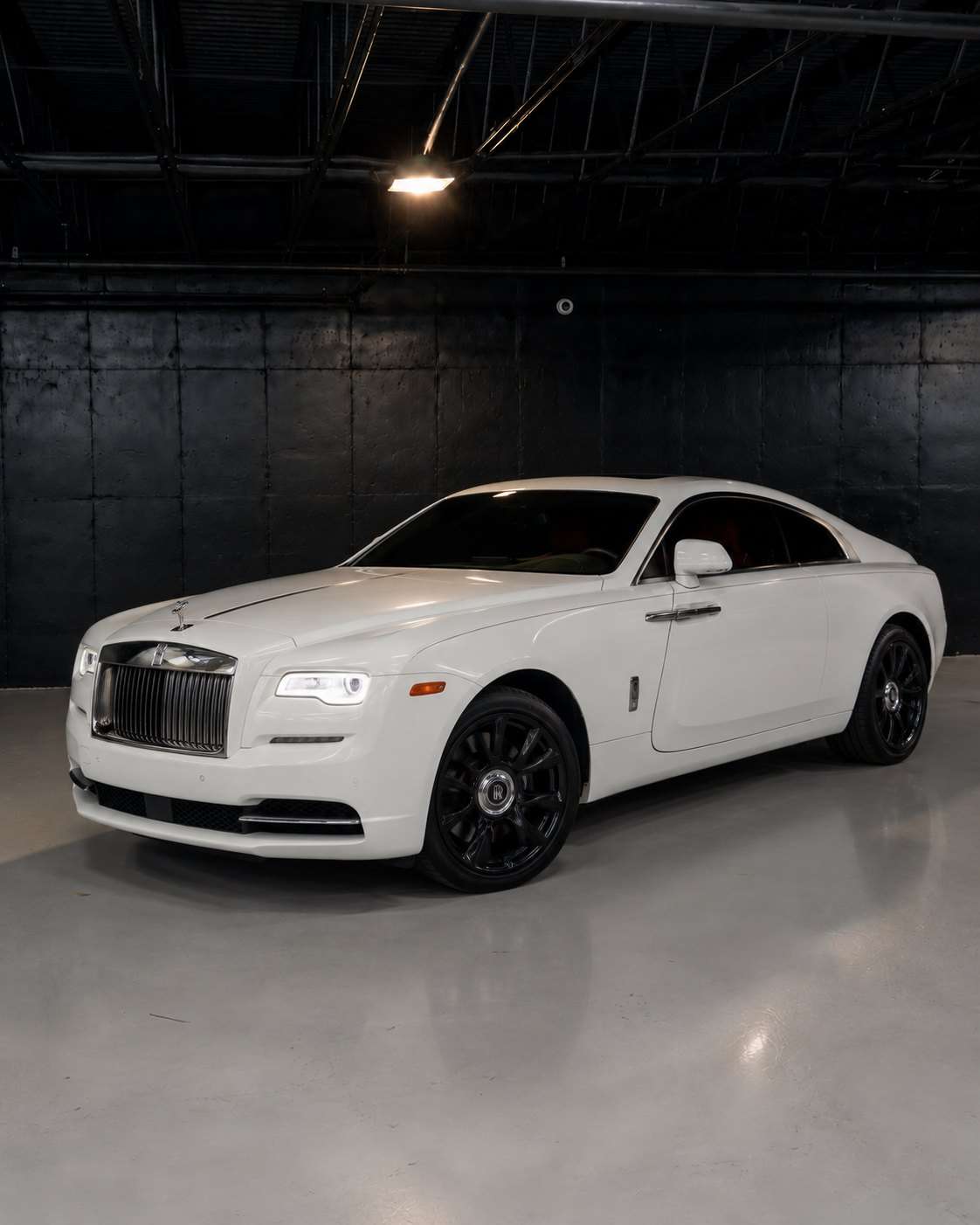 White Rolls-Royce Wraith with red interior, front three quarter in a dark studio