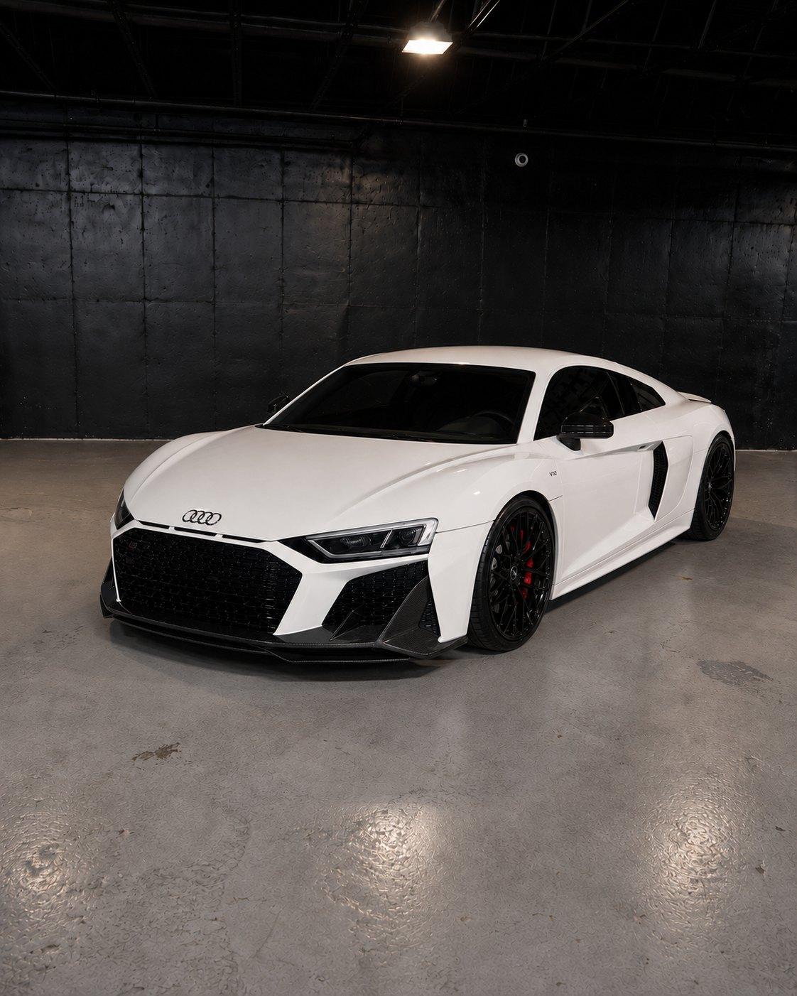 White Audi R8 V10 with red interior, front three quarter in a dark studio