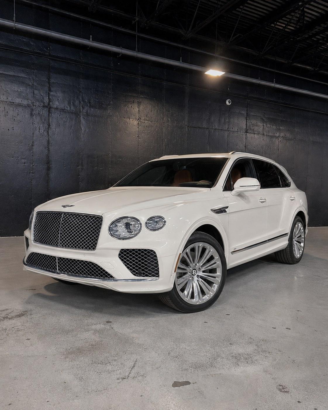 White Bentley Bentayga, front three quarter in a dark studio