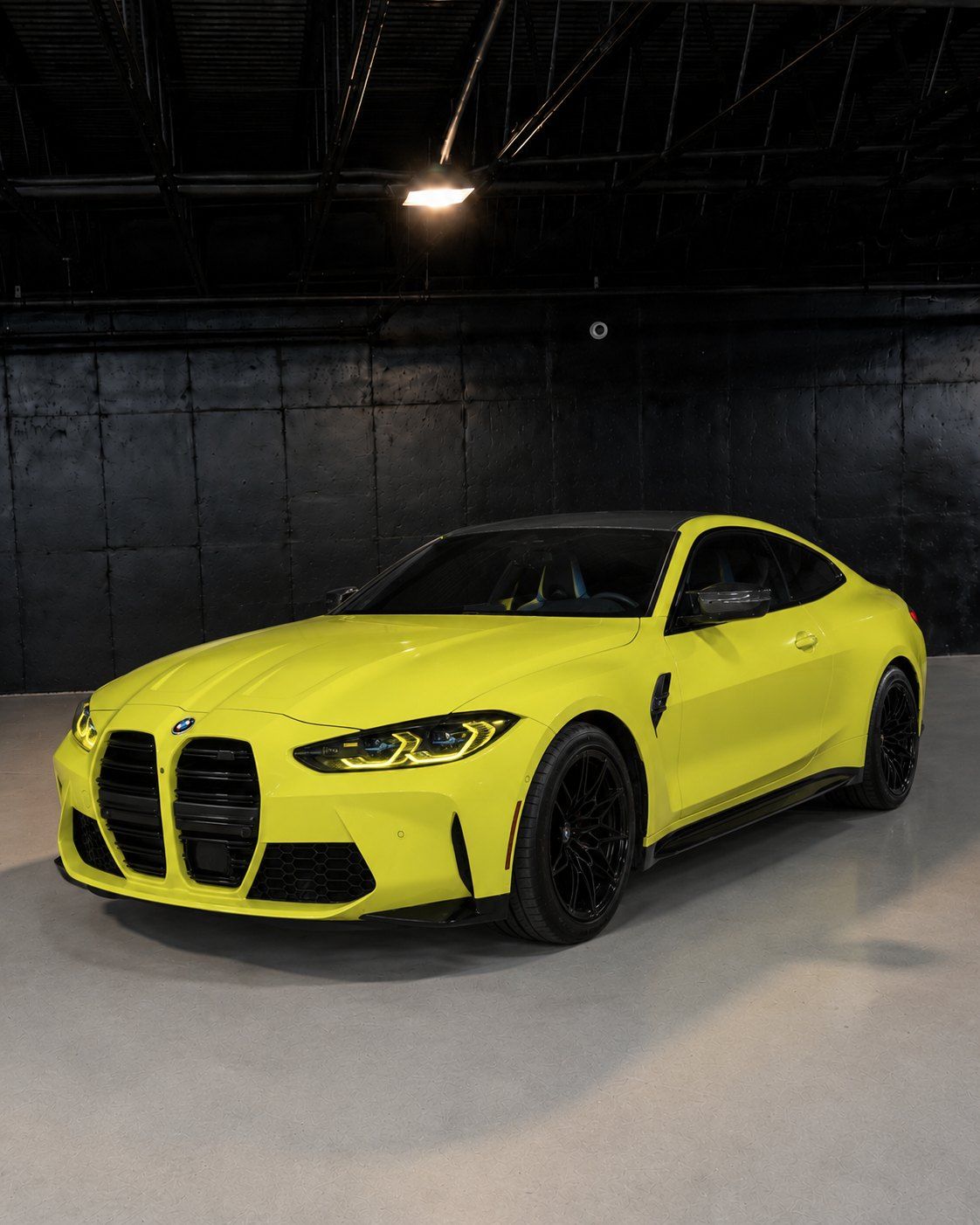 Sao Paulo Yellow BMW M4 Competition, front three quarter in a dark studio