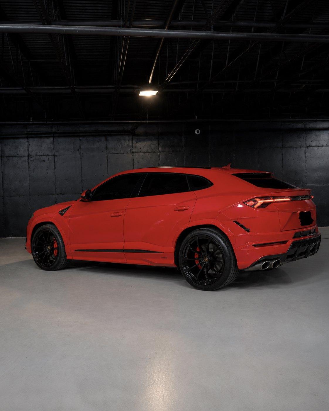 Red Lamborghini Urus, rear three quarter in the studio