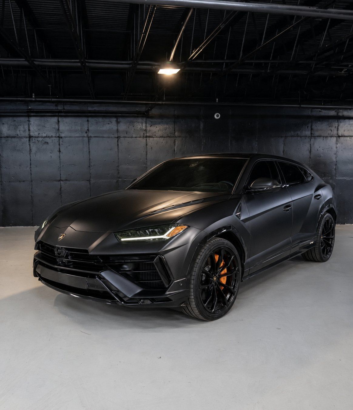 Matte black 2023 Lamborghini Urus S with orange calipers, front three quarter in a dark studio