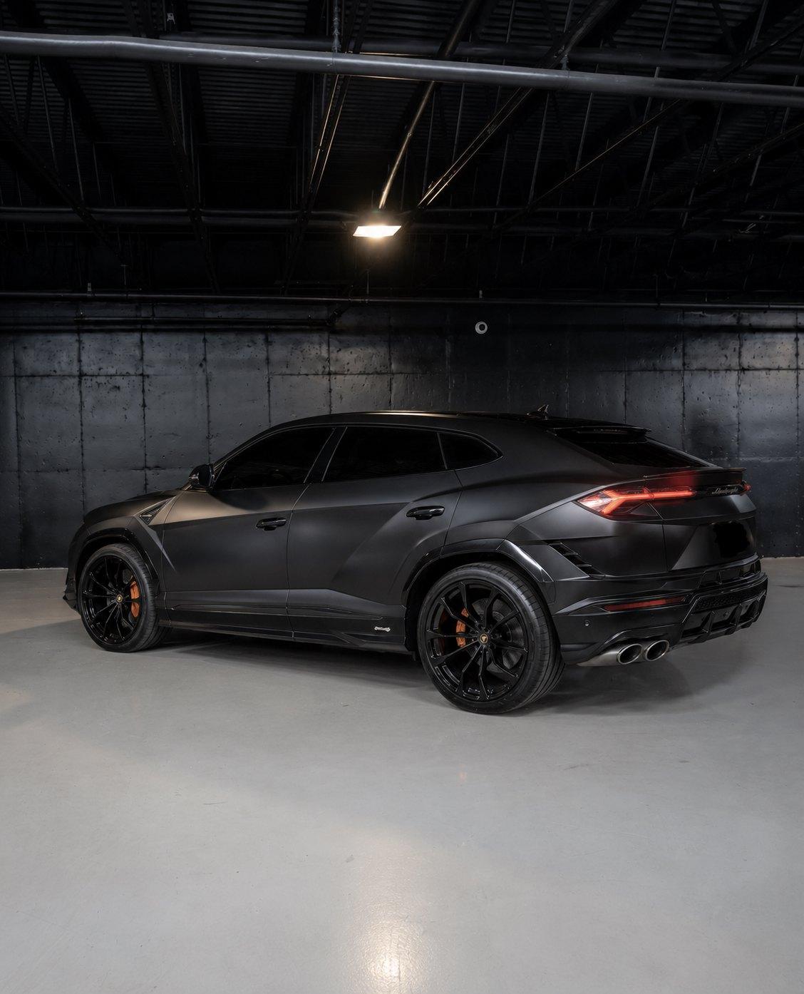 Matte black Lamborghini Urus S, rear three quarter in the studio